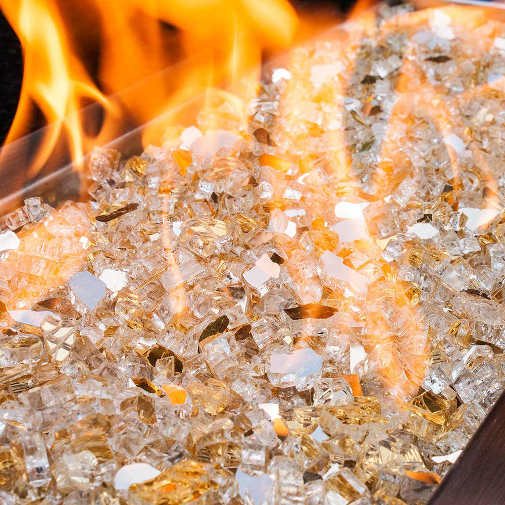 Close up of glimmering golden tempered fire glass in a large gas fire pit.