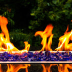 Wide view of large flames dancing across the surface of rough deep violet fire glass